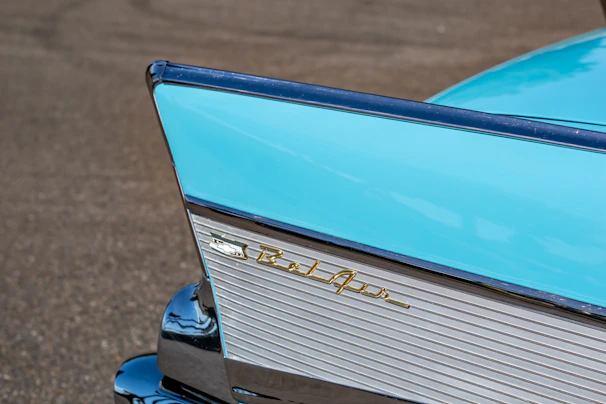 Rear shot of a pastel blue classic car showing its elegant tail fins and vintage license plate