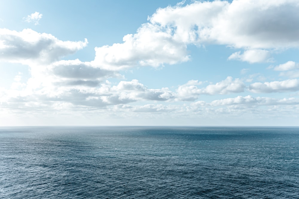 blue ocean under blue and white cloudy sky during daytime