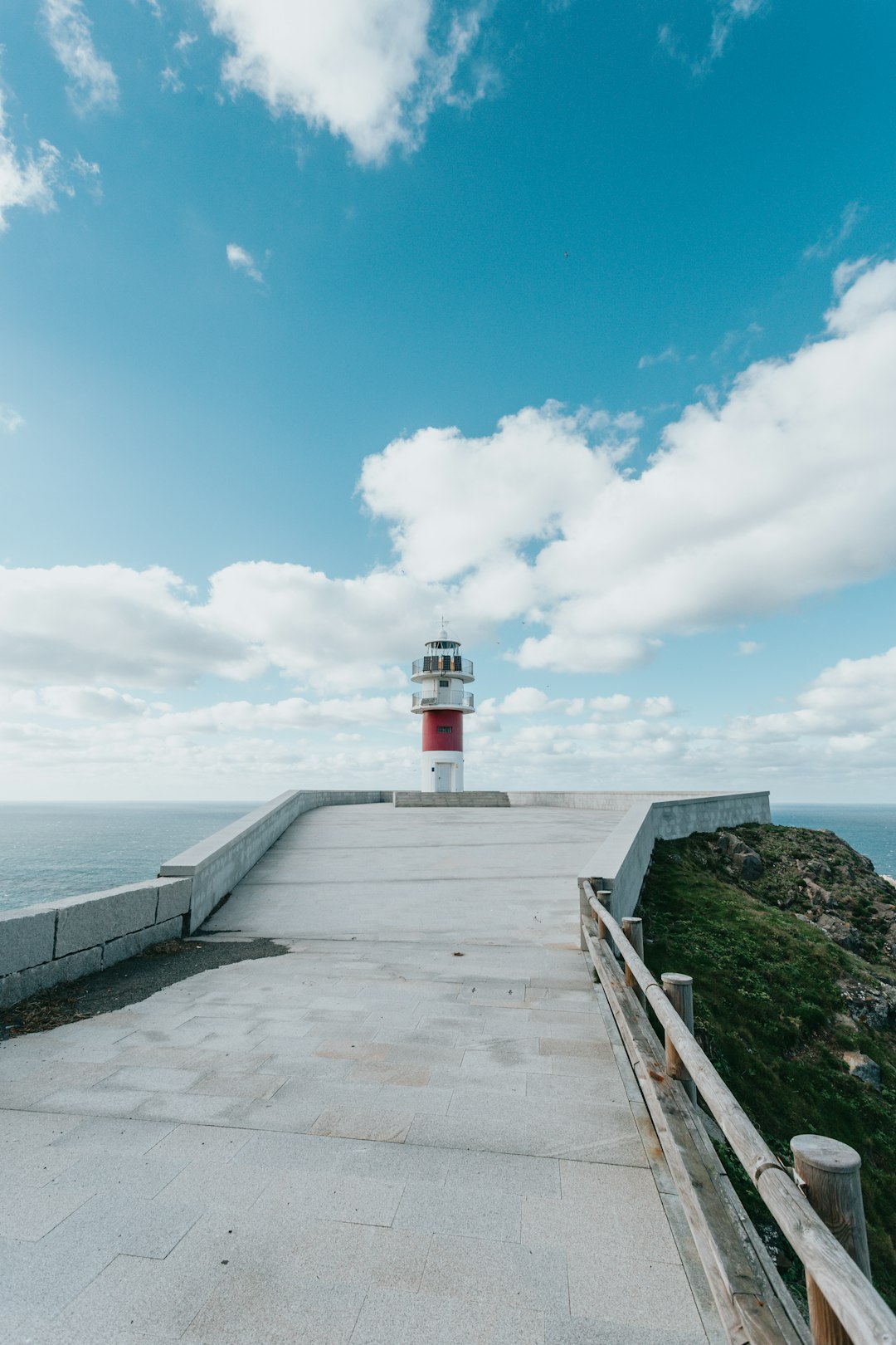 white and red lighthouse near body of water during daytime