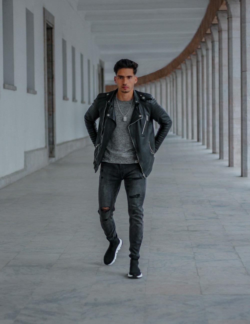 Sábana solo Hacia Foto Hombre con chaqueta de cuero negro y jeans azules parados en el piso  de concreto blanco – Imagen Rabat gratis en Unsplash