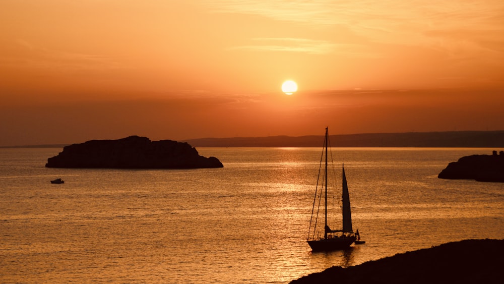 Silueta de velero en el mar durante la puesta del sol
