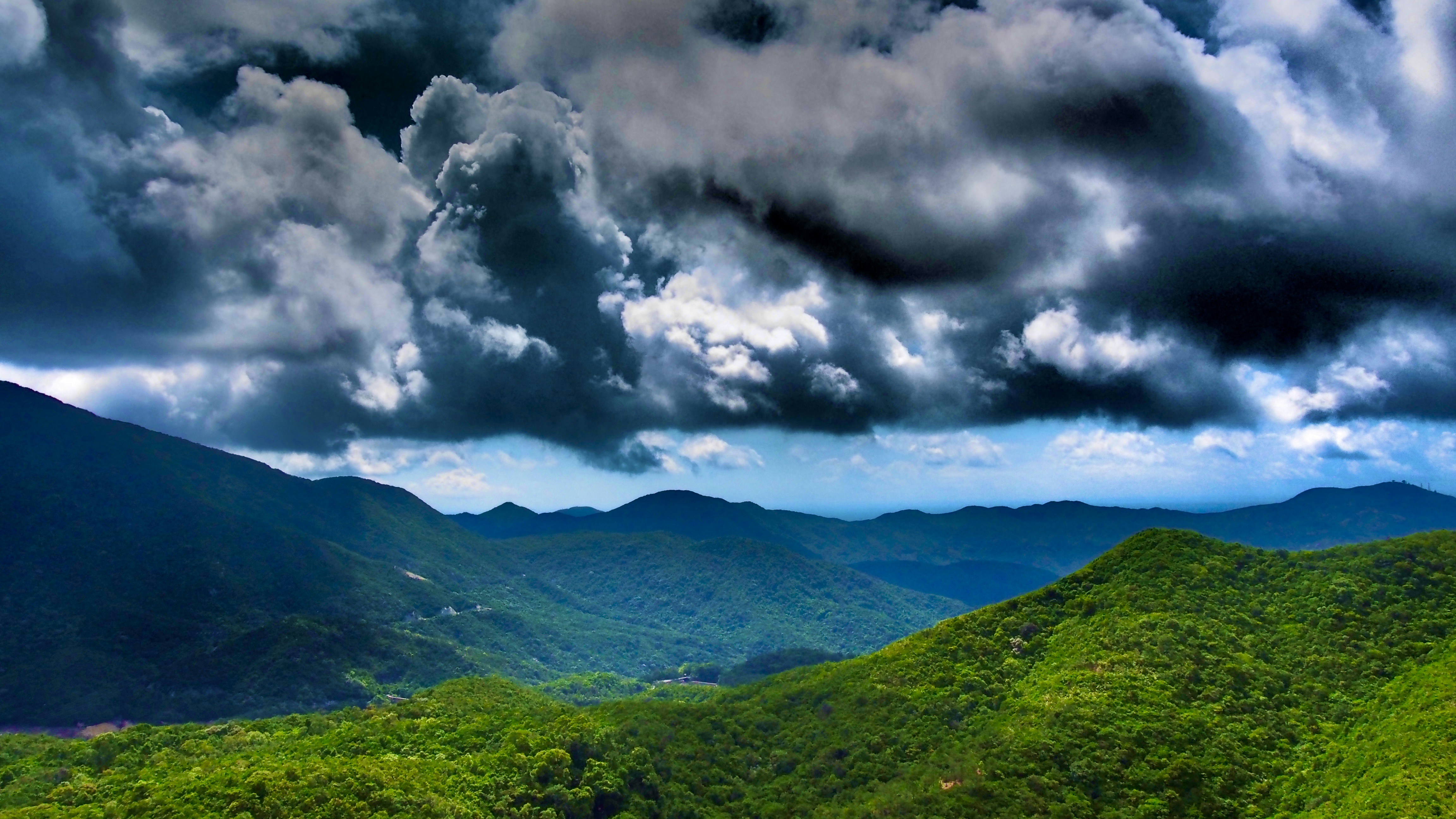 green mountains under white clouds