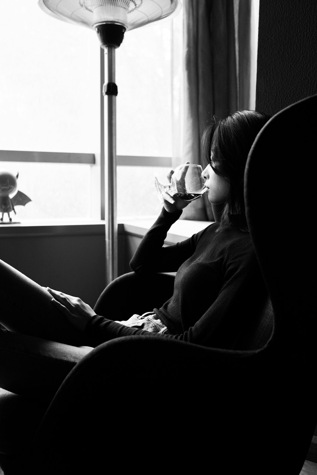 grayscale photo of woman sitting on chair