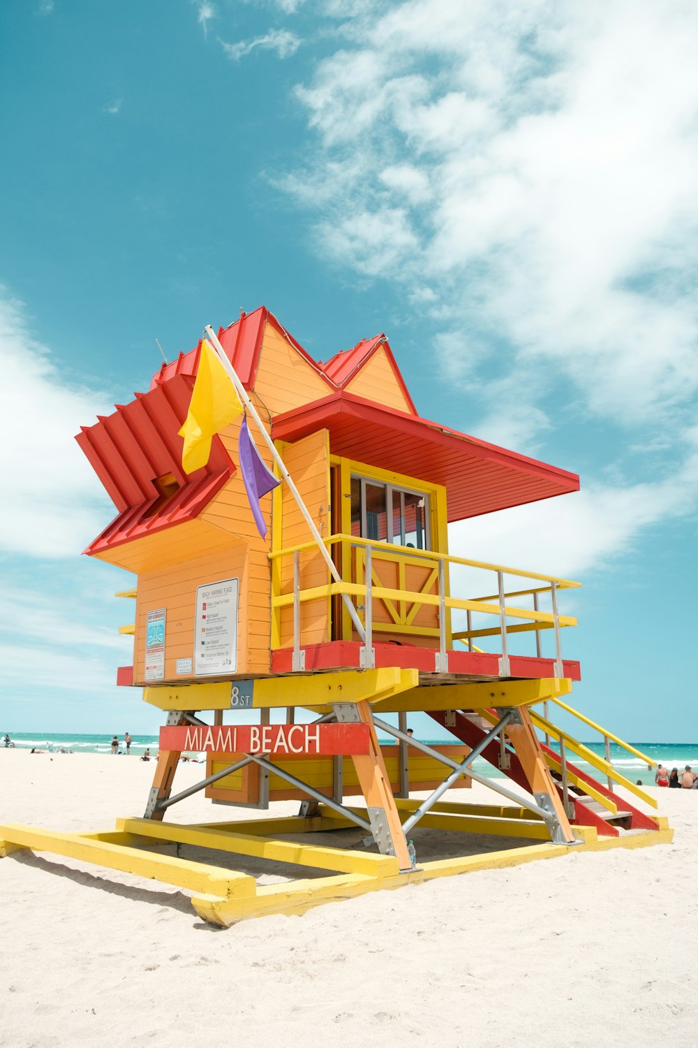昼間のビーチショアにある赤と白の木造のライフガードハウス