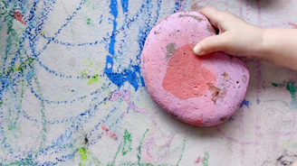 person holding pink and blue paint