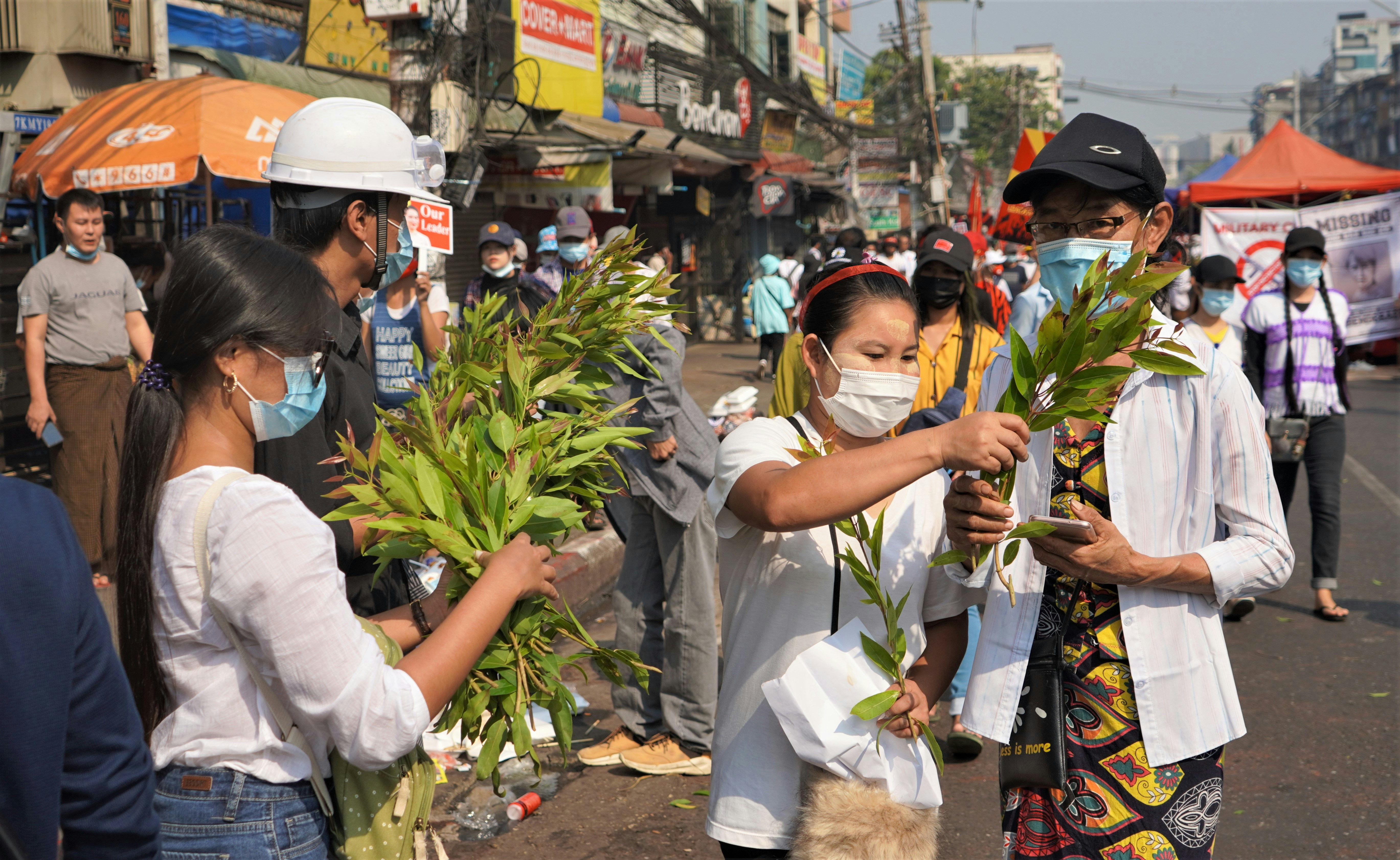 man in white dress shirt and yellow hat holding woman in white dress