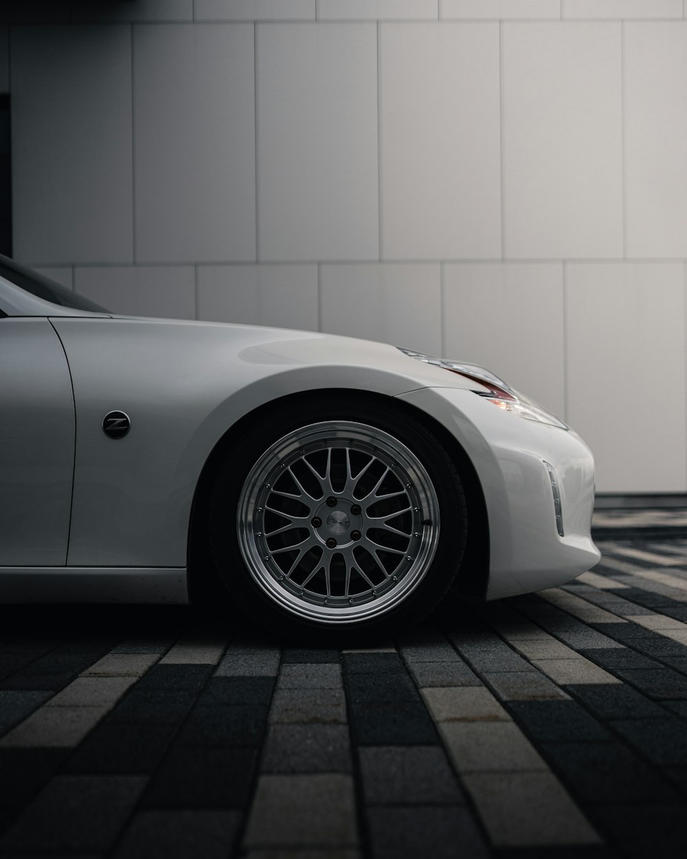 white porsche 911 parked near white wall