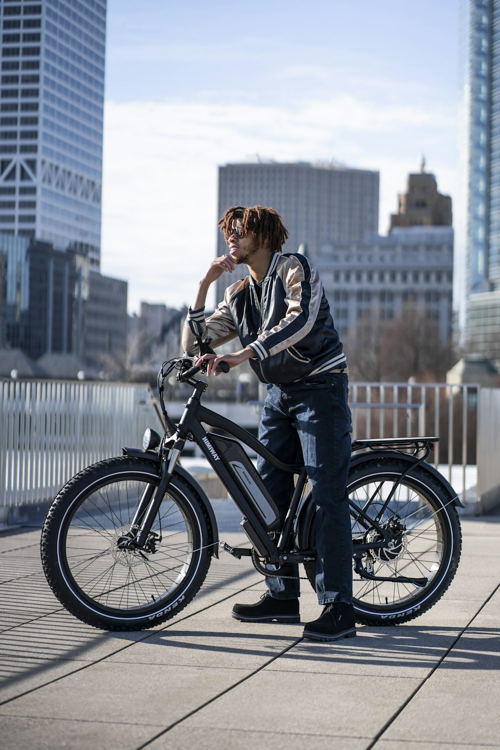 man in black and white jacket riding on black bicycle during daytime