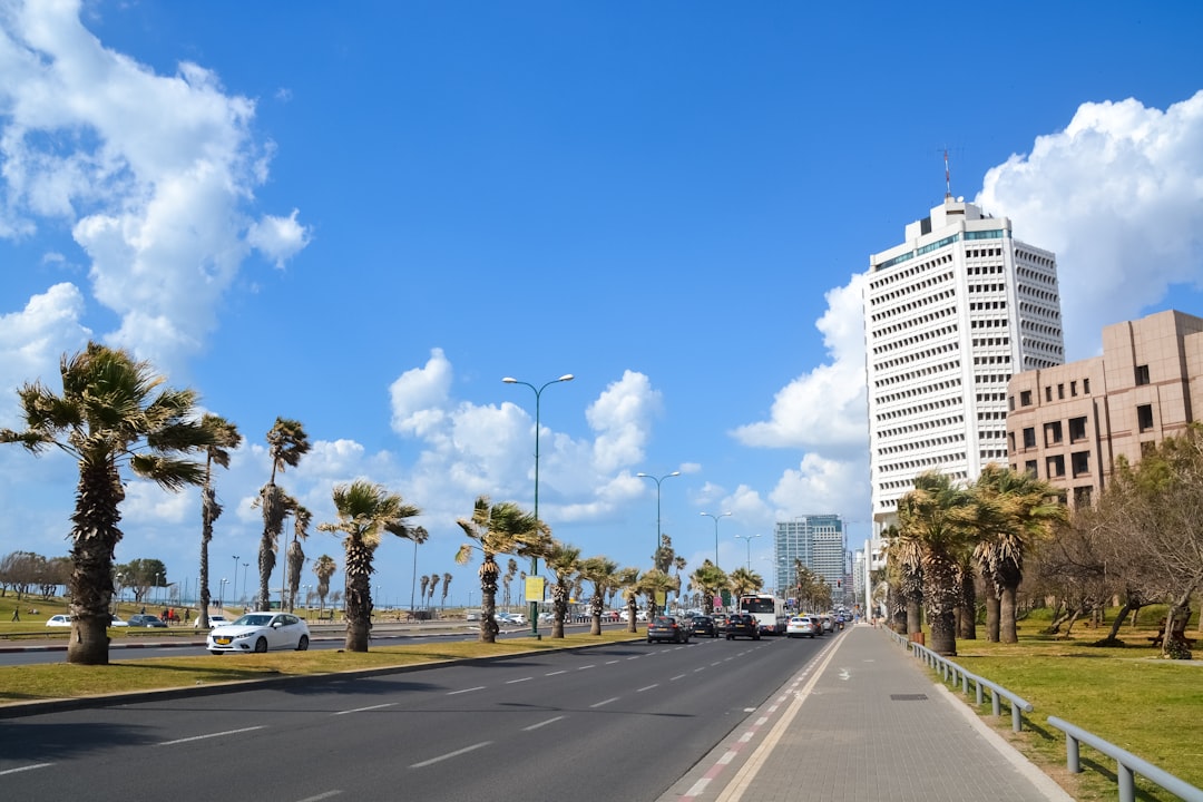 white concrete building near green trees under blue sky during daytime