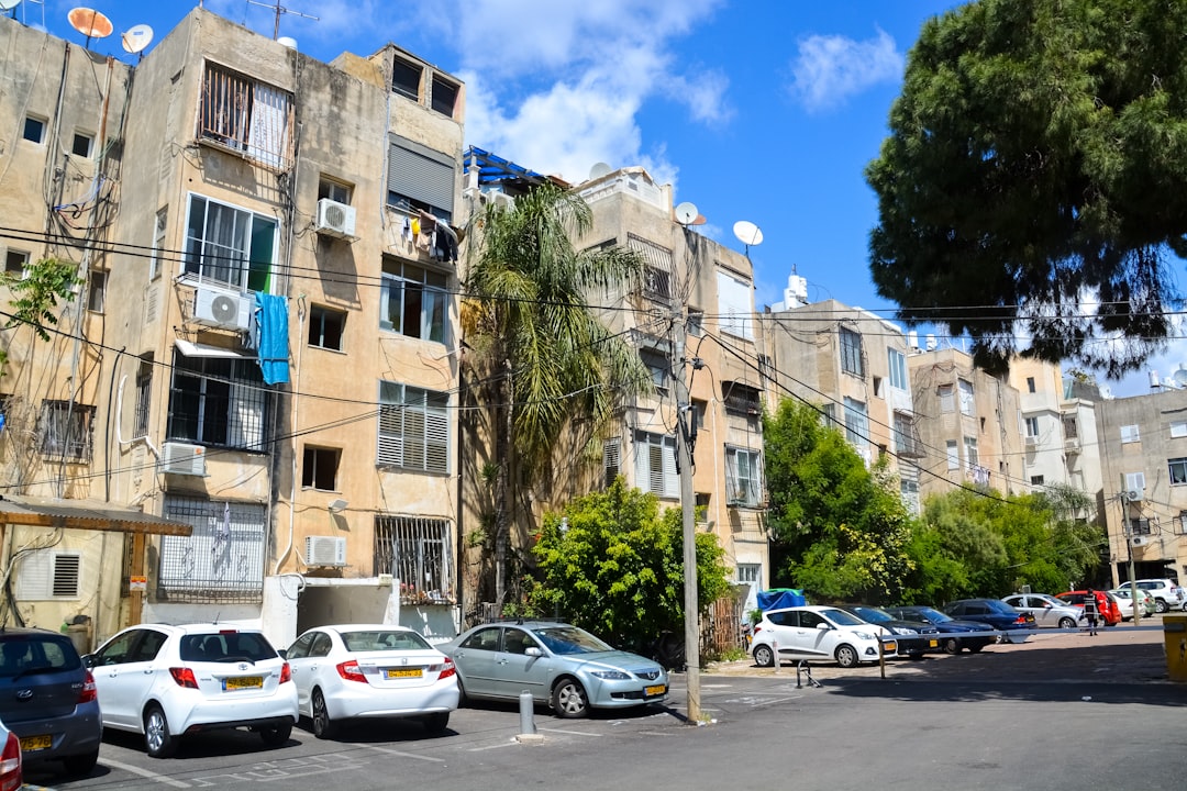 cars parked in front of brown building during daytime