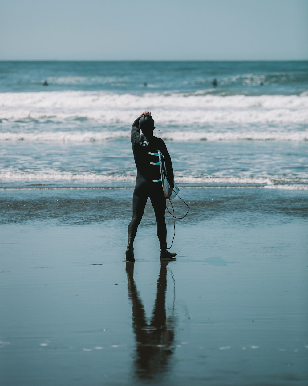 woman in black wet suit standing on beach during daytime