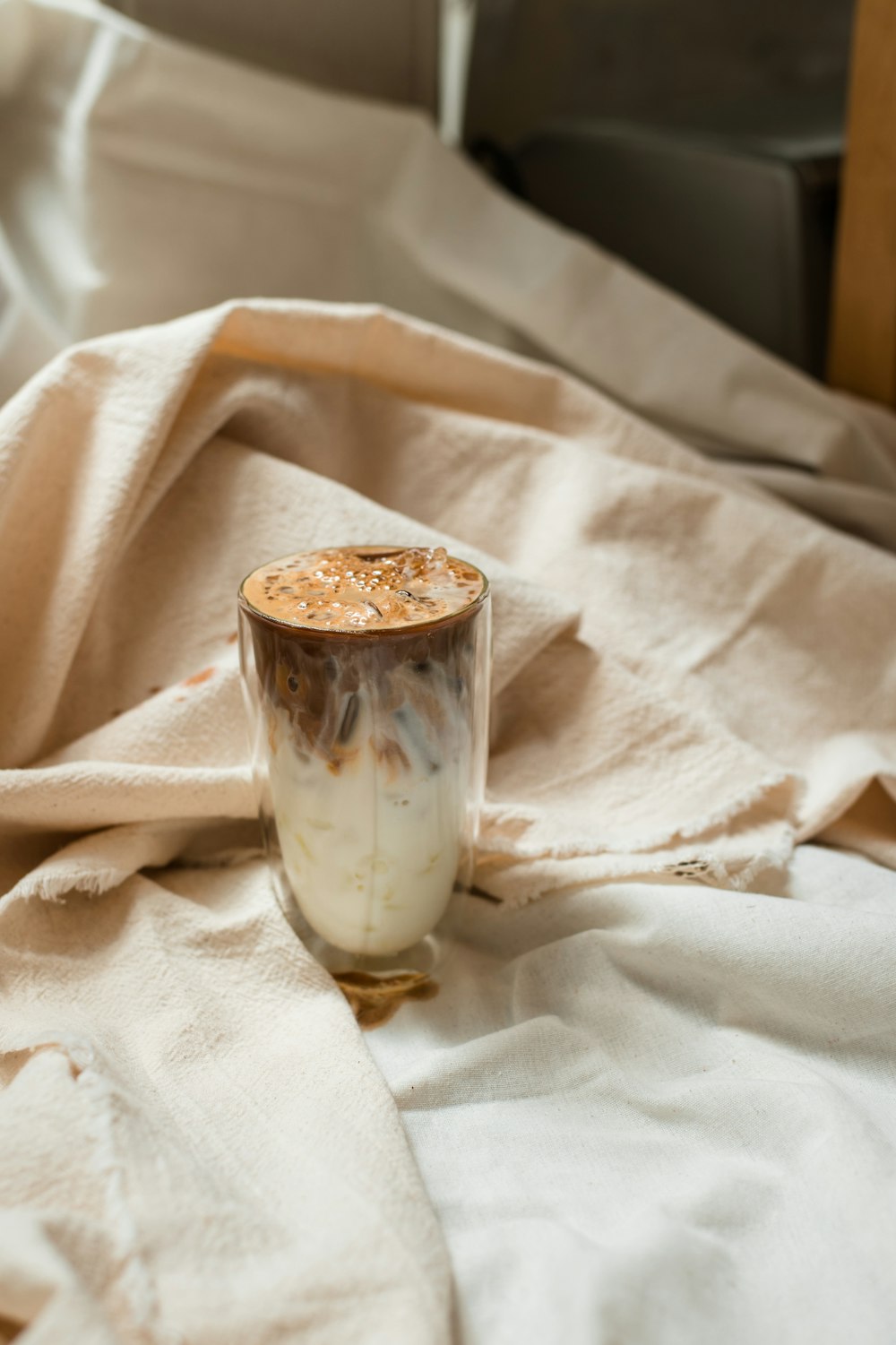 clear glass cup on white textile