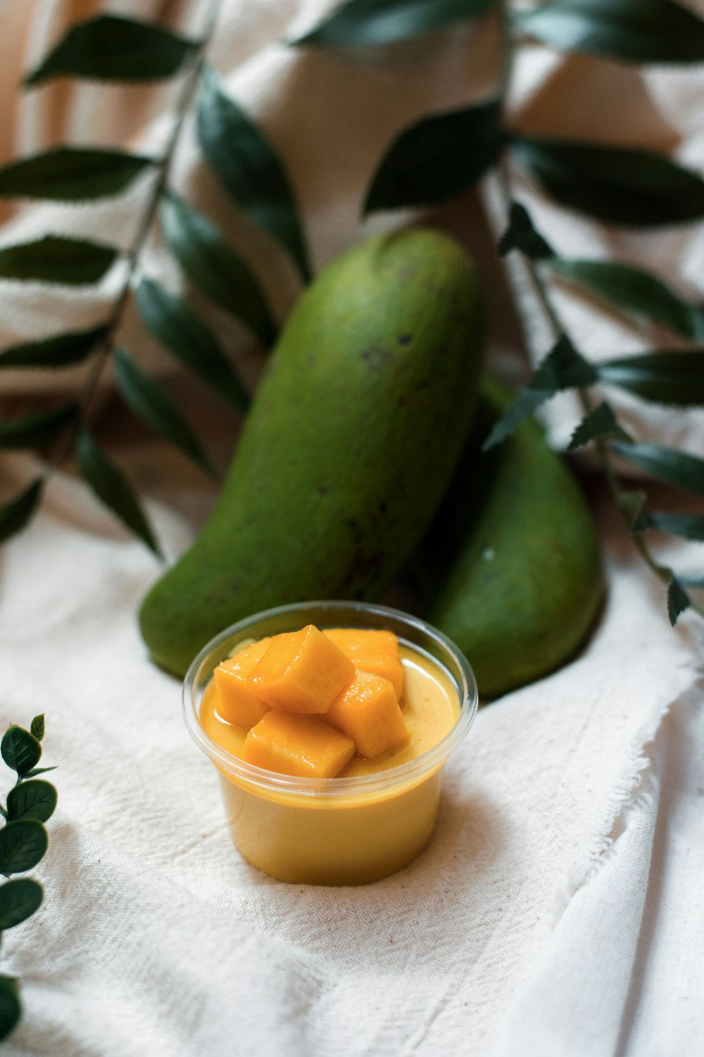 pepino en rodajas junto a un vaso transparente con líquido amarillo