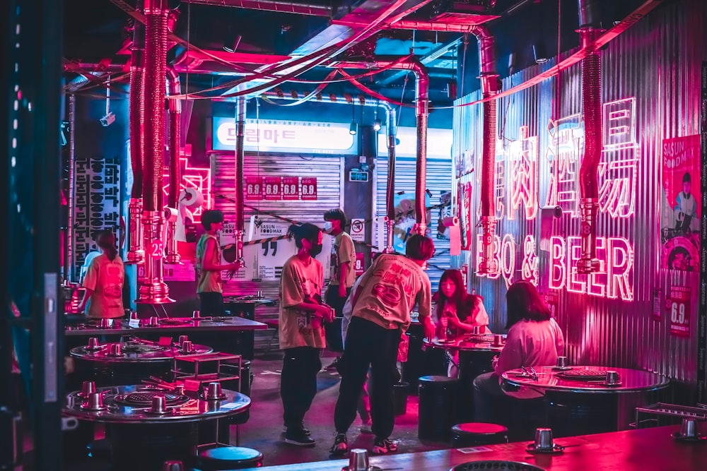 people sitting on chair near red and white canopy tent during night time