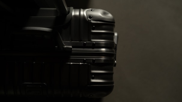 A close-up shot of a phere llc suitcase highlighting the reinforced hardware and scratch-resistant fabric in a sleek black color.