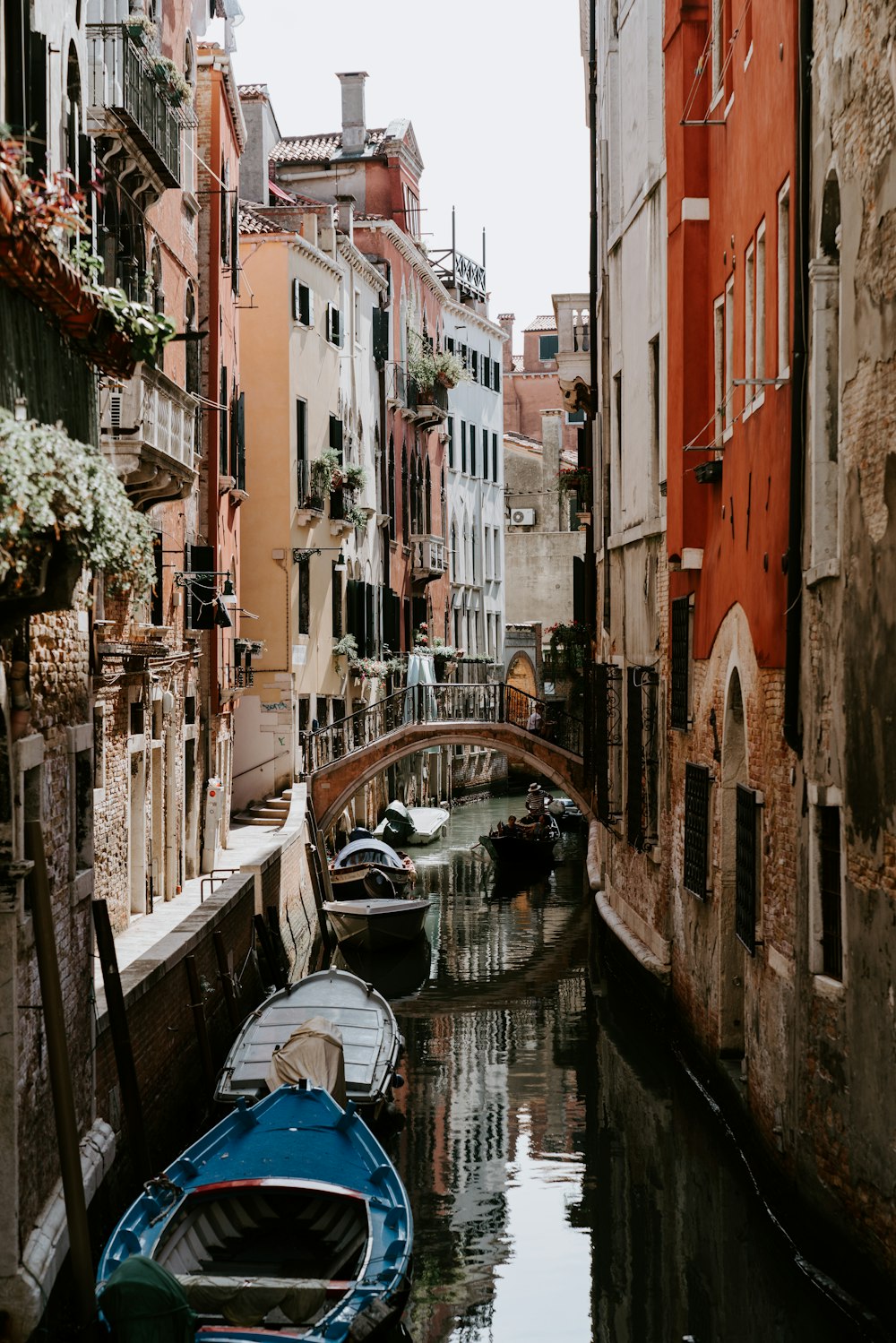 boats on river between buildings during daytime