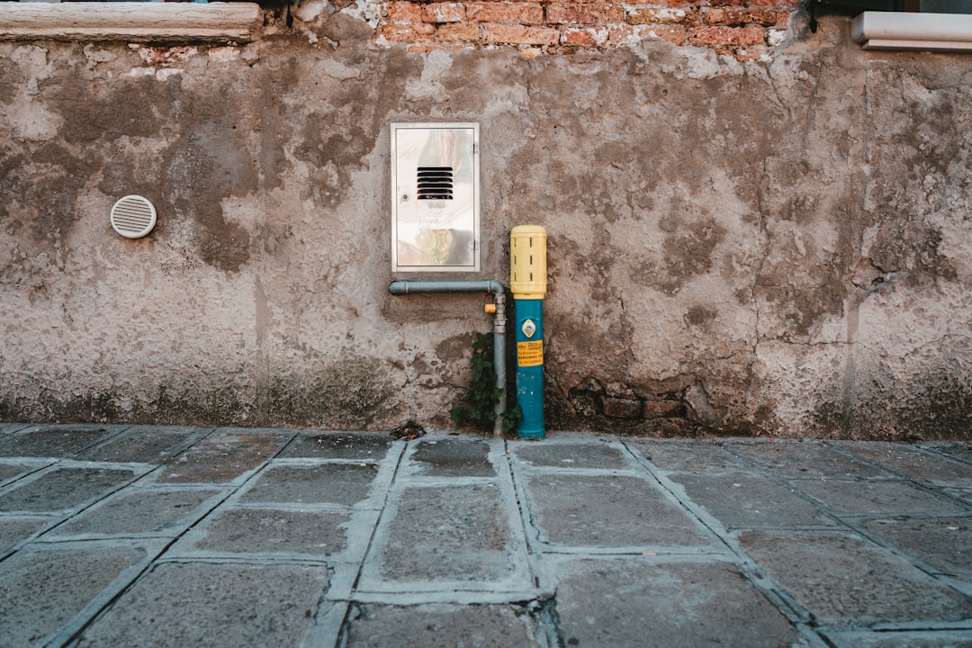 white and gray digital device mounted on brown brick wall