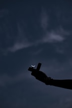 A serene image of hands gently holding a small, glowing cross against a soft, blurred background.