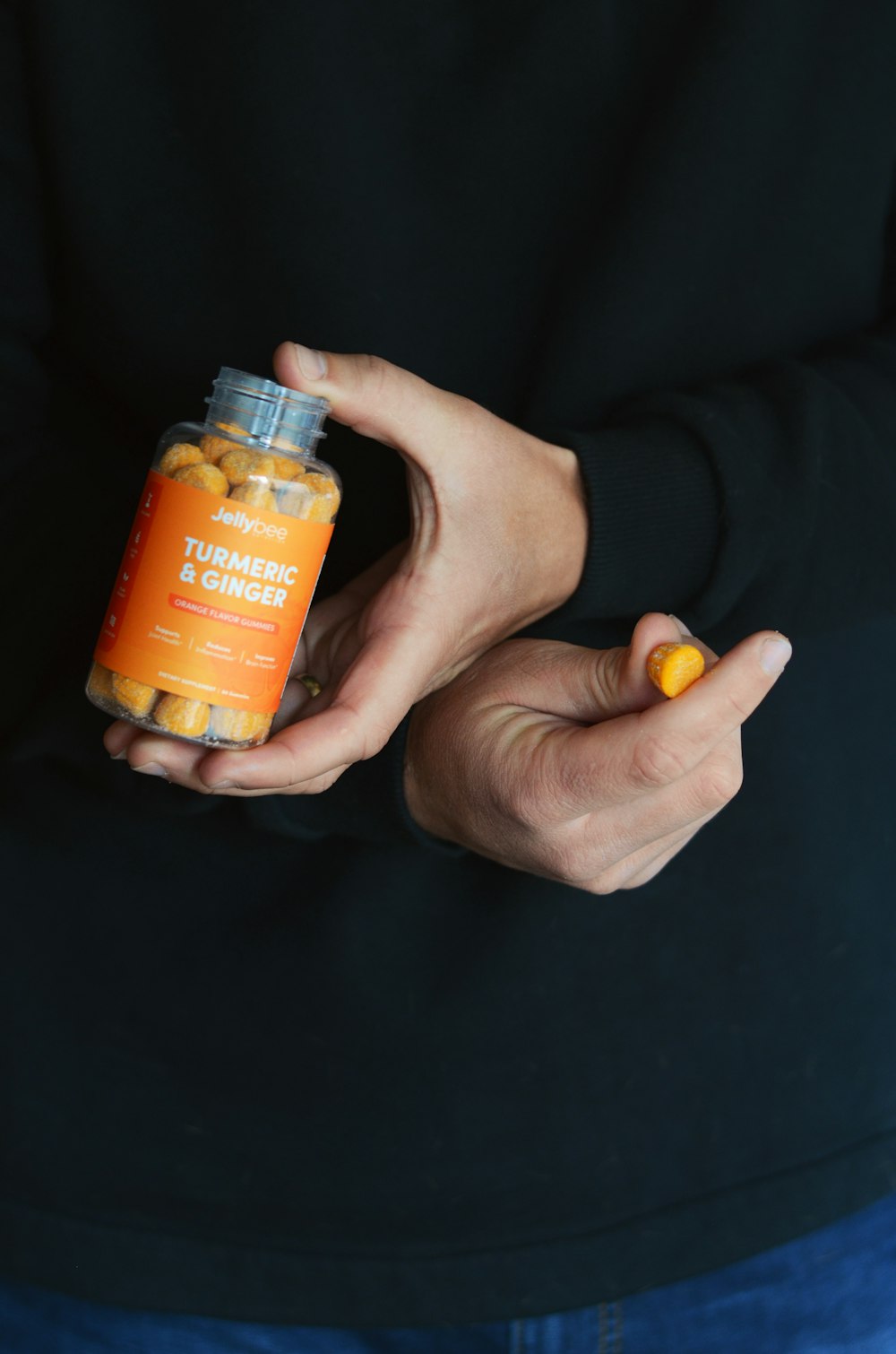 person holding orange plastic bottle