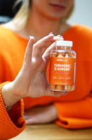 person holding orange nail polish