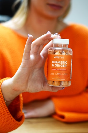person holding orange nail polish