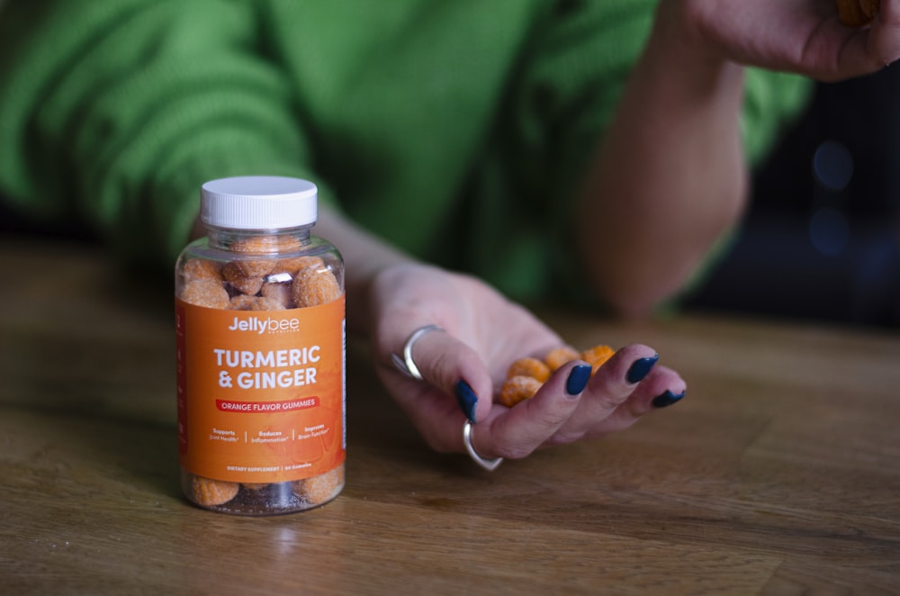 person holding orange labeled bottle