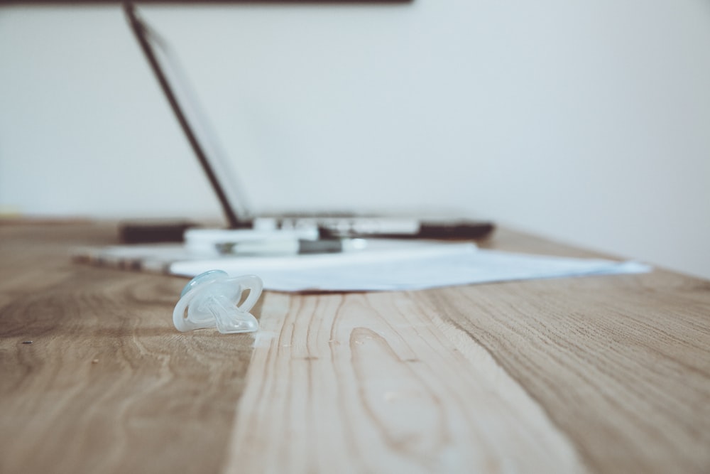 silver macbook on brown wooden table