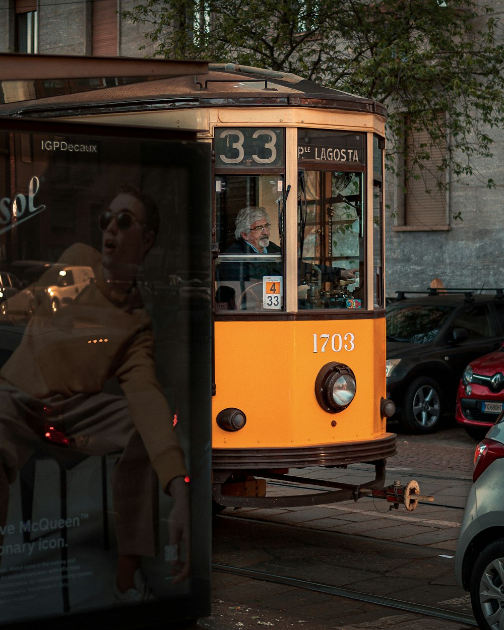 man in brown jacket sitting on yellow bus during daytime