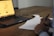 A person studying sports statistics on a laptop with a notepad and pen beside them.