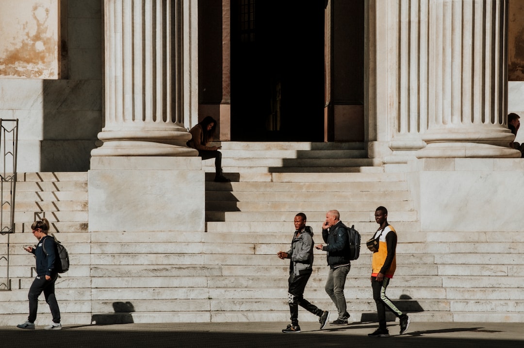 3 men in black suit standing on gray concrete stairs