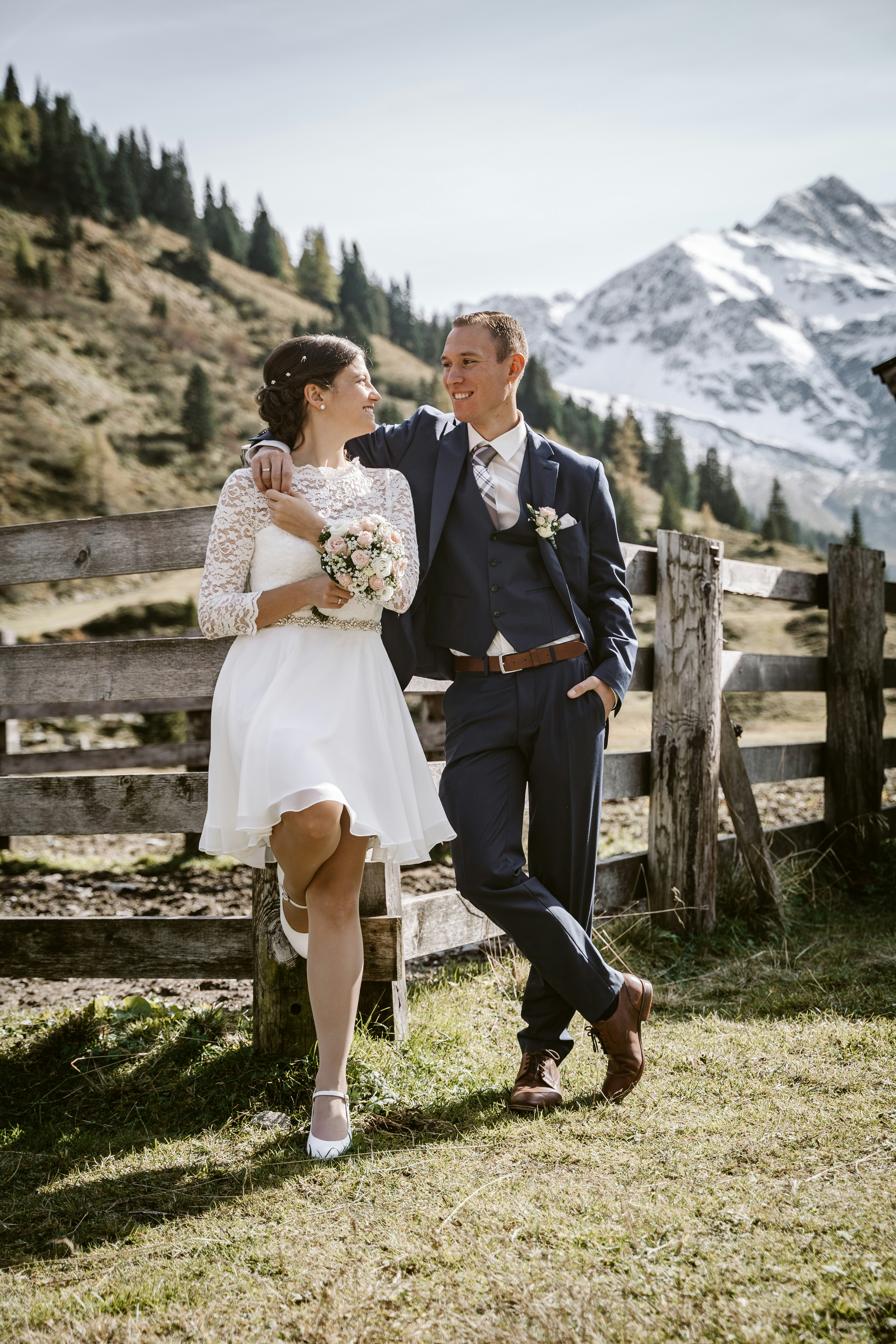 man in black suit and woman in white dress kissing