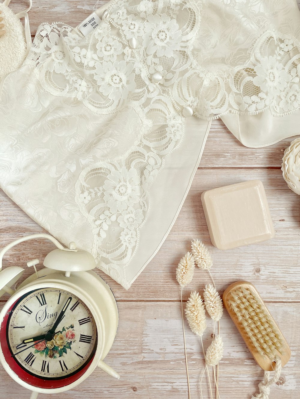 white floral textile beside brown wooden round analog wall clock