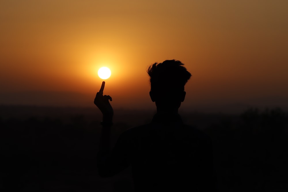 silhouette of woman holding sun