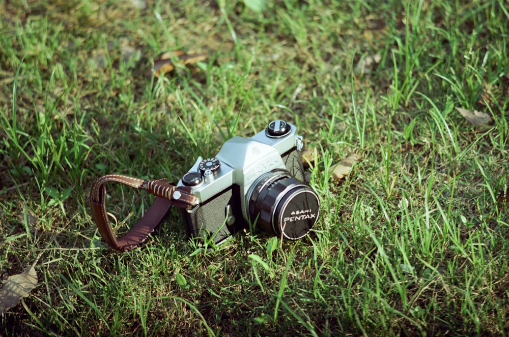 black and silver dslr camera on green grass during daytime