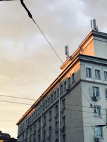 Package unit being carefully installed outside a commercial building at sunset