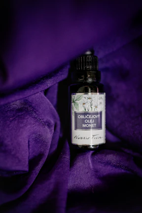 Close-up of a violet earlobe lotion bottle with delicate purple floral graphics.