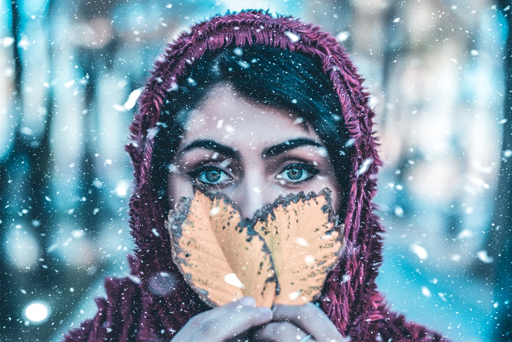 woman in red scarf covering her face with her hand