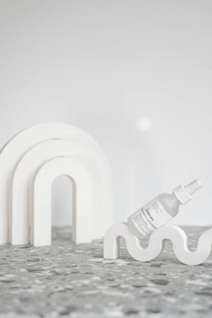 A minimalist flat lay of Syalabi Beuty hand body lotion bottle on a clean white surface.