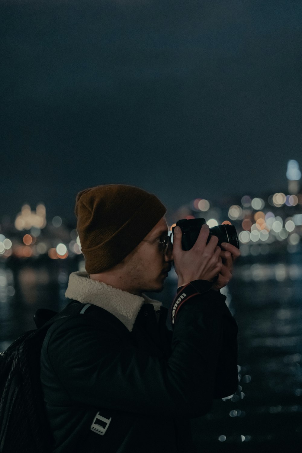 person in black jacket wearing brown knit cap and black sunglasses