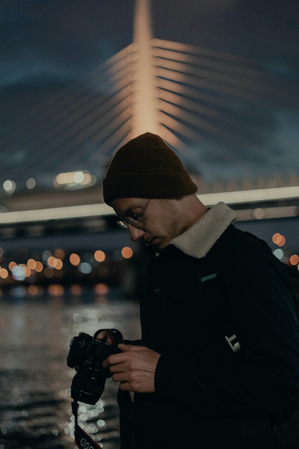 man in black jacket holding black dslr camera