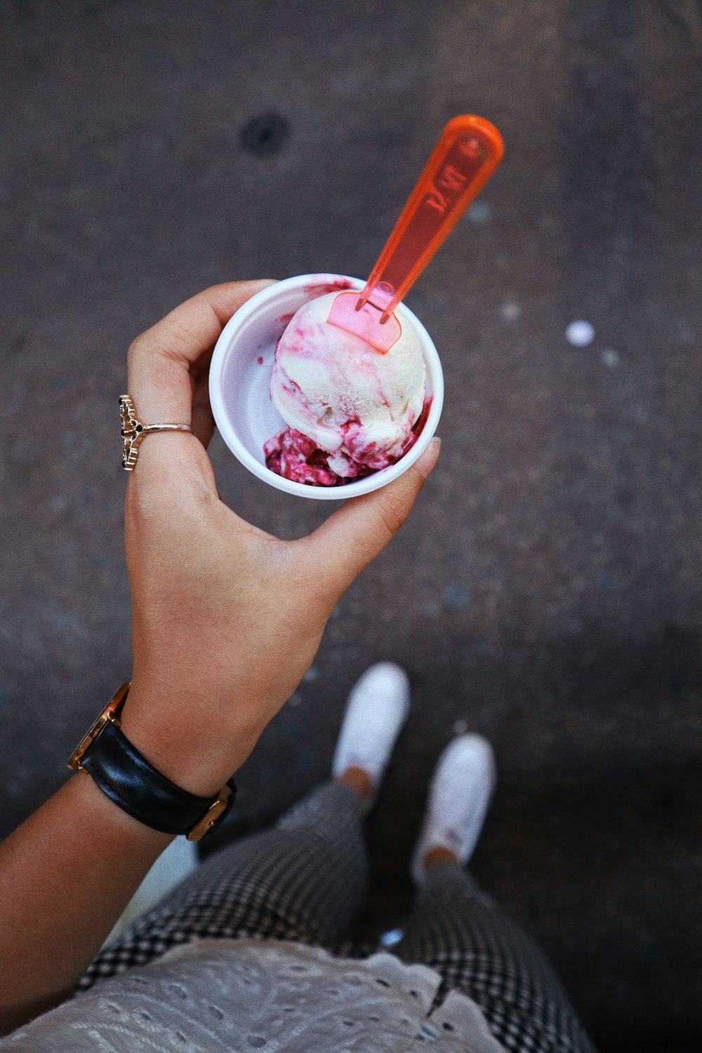 person holding pink and white plastic cup