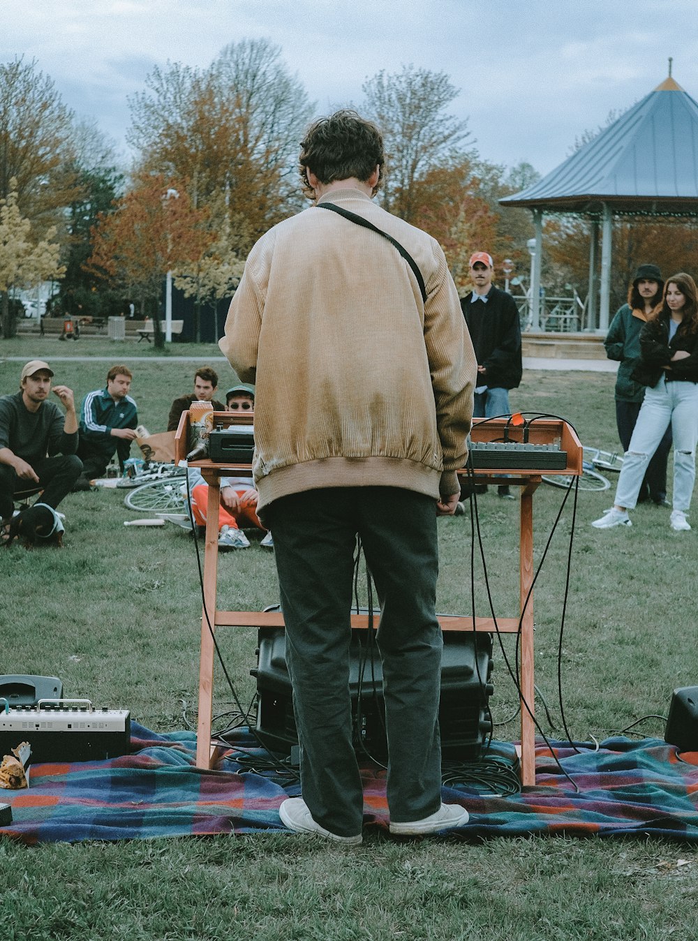 man in brown sweater and black pants standing on blue and red mat