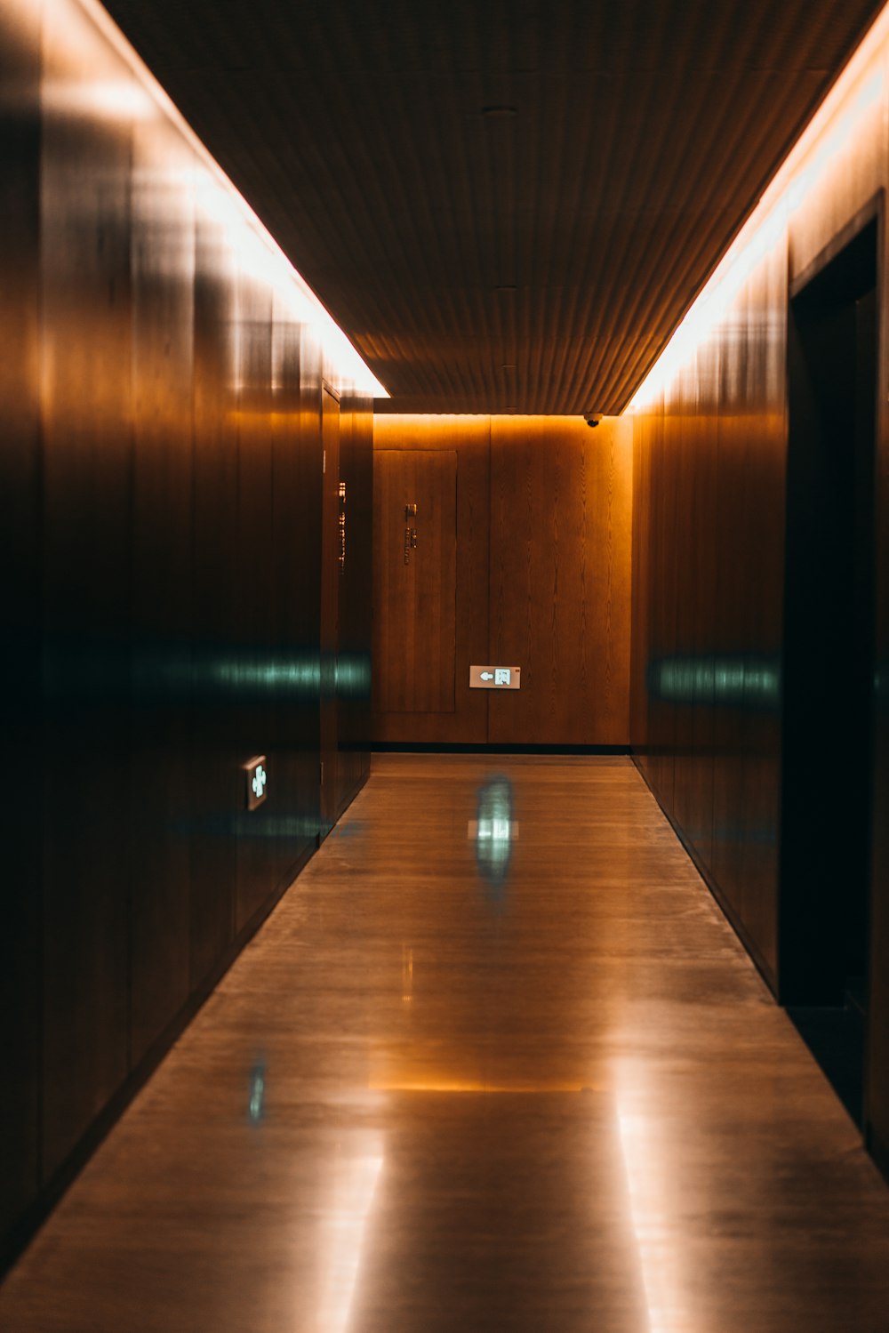 brown wooden hallway with lights turned on during night time
