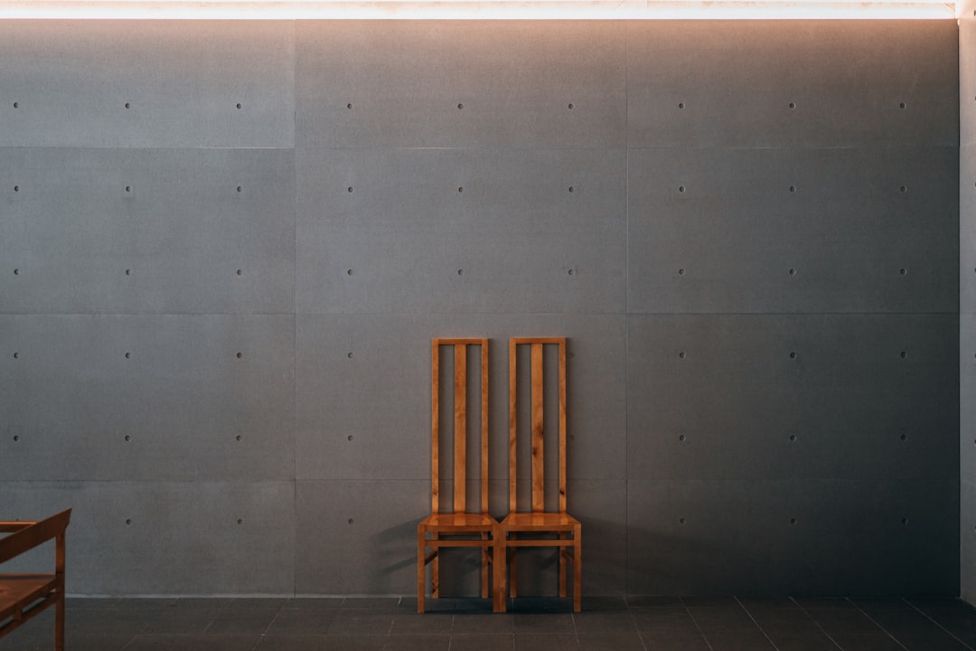 brown wooden chair beside white wall