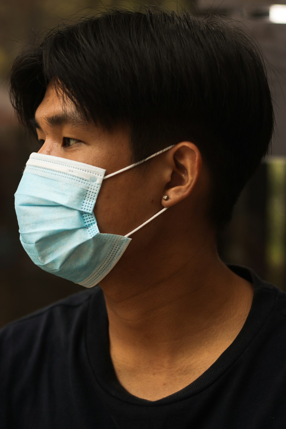 man in black crew neck shirt with white face mask