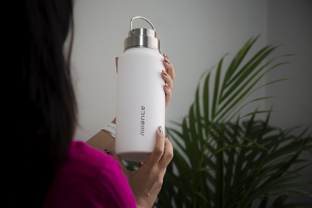 person holding white plastic bottle