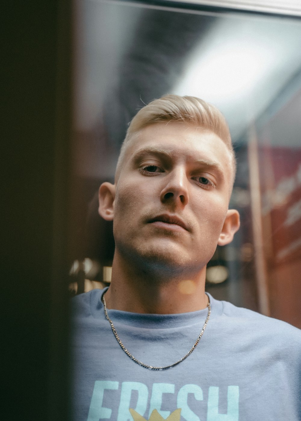 a man with blonde hair wearing a blue shirt