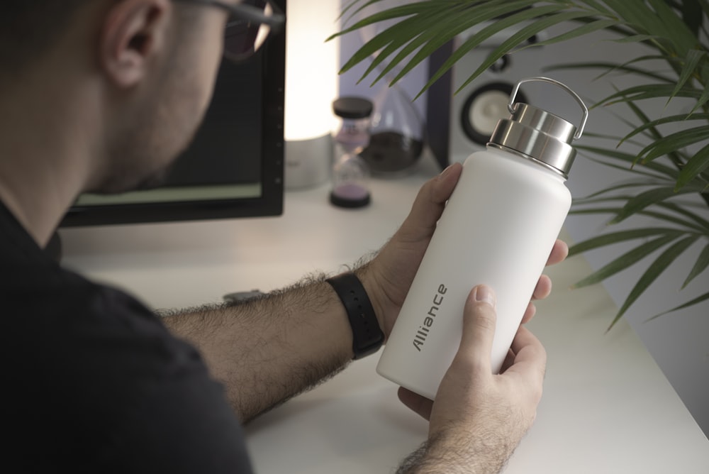 person holding white and black calvin klein bottle