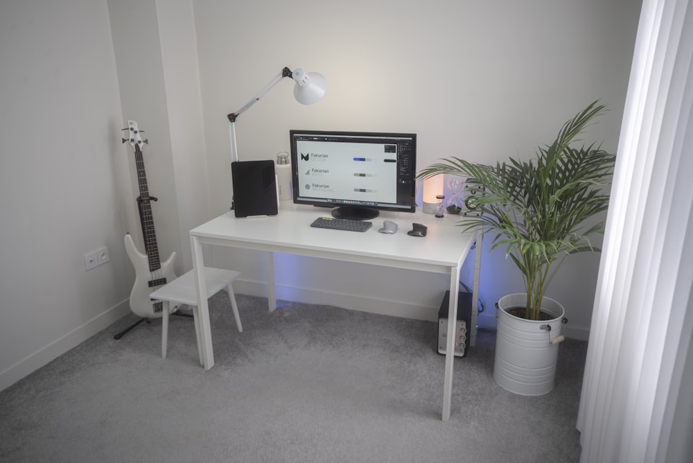 흰색 나무 책상에 검은 평면 스크린 컴퓨터 모니터