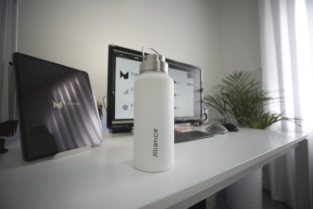 white and black plastic bottle on white table